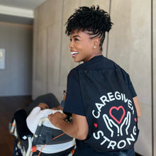 Load image into Gallery viewer, Actress Brandee Evans wearing a "Caregiver Strong" tote bag.